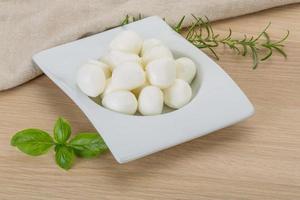 Mozzarella kaas in een kom Aan houten achtergrond foto