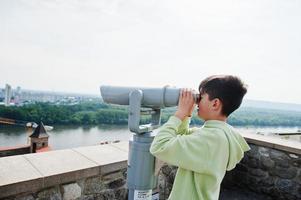 jongen op zoek Bij toeristisch telescoop van Bratislava visie, Slowakije. foto