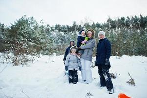 moeder met vier kinderen in de winternatuur. buiten in de sneeuw. foto