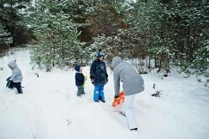 moeder met drie kinderen in de winternatuur. buiten in de sneeuw. foto