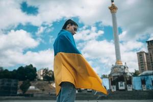 jong vrouw gedekt met de oekraïens vlag foto