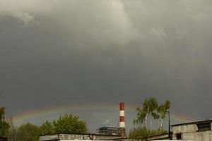regenboog in regenachtig lucht. hemel- landschap in industrieel Oppervlakte. foto