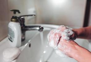 Mens het wassen handen naar beschermen tegen de coronavirus foto