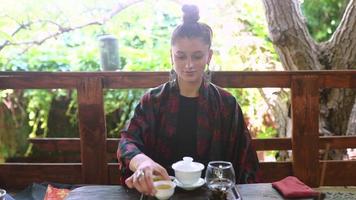 jong vrouw demonstreert een kom van thee naar de camera foto