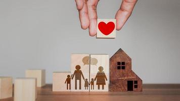 idee van toevoegen liefde en warmte naar de familie. hand- Holding houten kubus blok met rood hart icoon voor familie. foto