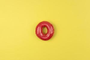 een smakelijk geglazuurd donut leugens Aan een geel achtergrond foto