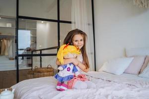 schattig glimlachen weinig meisje kind spelen met haar pop foto