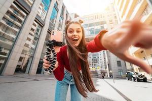 mooi vrouw blogger op zoek Bij de camera Aan de straat. foto