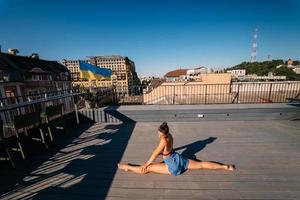 jong vrouw beoefenen yoga Aan de dak van een gebouw foto