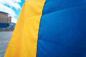 kleding stof gebogen vlag van Oekraïne. dichtbij omhoog schot, achtergrond foto