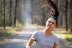 mooi jong vrouw rennen in groen park Aan zonnig zomer dag foto