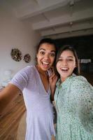 twee meisjes nemen selfies in de leven kamer foto