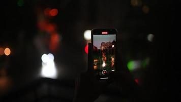 Mens schiet video van de nacht straat Aan een smartphone foto