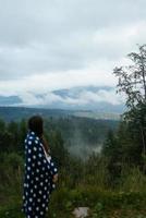 vrouw staand Aan top van een heuvel, tegen de achtergrond van een vallei foto