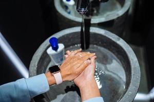 Mens het wassen handen naar beschermen tegen de coronavirus foto