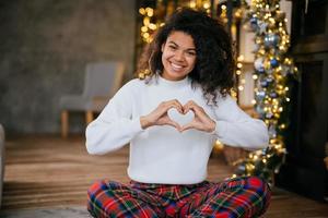 mooi jong Afrikaanse Amerikaans vrouw maken hart vorm met haar handen foto