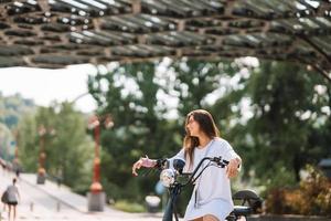 jong mooi vrouw en een elektrisch scooter, ecologisch vervoer foto