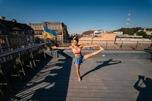 jong vrouw beoefenen yoga Aan de dak van een gebouw foto