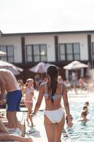 mooi jong vrouw in bikini resting buitenshuis door de zwembad foto