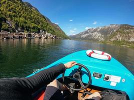 Mens controles een motorboot Aan een berg meer foto