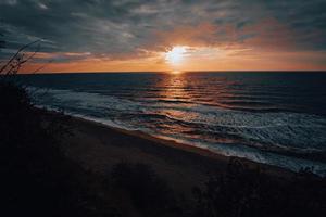 dramatisch zee zonsondergang Aan de kust foto