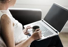 blanke vrouw met laptop op sofa foto