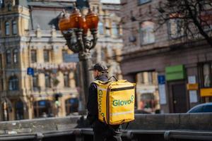 kiev, Oekraïne, maart 28, 2020, glovo huis levering voedsel door fiets, gaat verder gedurende n-cov19 coronavirus pandemisch foto