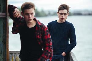 twee jongens staan in een verlaten gebouw aan het meer foto