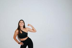 vrolijk mooi glimlachen sportief vrouw demonstreren biceps foto
