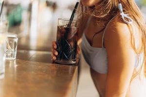 vrouw resting Aan de strand bar, drinken een verfrissend cocktail. foto