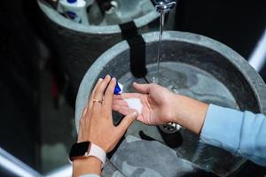 Mens het wassen handen naar beschermen tegen de coronavirus foto