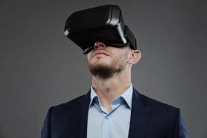 man in een pak met virtual reality bril op zijn hoofd.