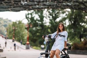 jong mooi vrouw en een elektrisch scooter, ecologisch vervoer foto