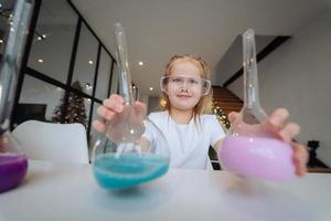 weinig meisje maken chemisch experimenten Bij huis foto