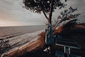 jong vrouw duurt afbeeldingen van de zee zonsondergang door smartphone foto