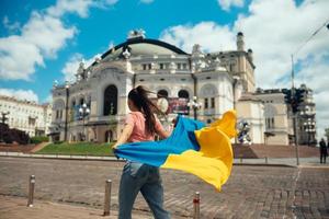 jong vrouw met nationaal vlag van Oekraïne Aan de straat foto