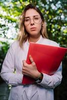 jong agrarisch ingenieur werken in serre. jong vrouw wetenschapper op zoek Bij de camera foto