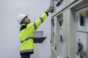 elektrisch ingenieur Mens controle Spanning Bij de macht distributie kabinet in de controle kamer, preventief onderhoud jaarlijks, thailand elektricien werken Bij bedrijf foto