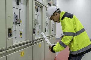 elektrisch ingenieur Mens controle Spanning Bij de macht distributie kabinet in de controle kamer, preventief onderhoud jaarlijks, thailand elektricien werken Bij bedrijf foto