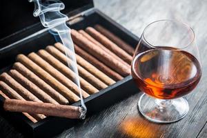 brandende sigaar en cognac in glas foto