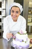 bakker versiert een cake met kleurstof foto