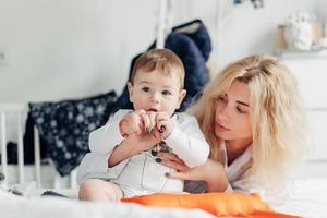 moeder speelt met haar baby in de slaapkamer foto