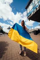 jong vrouw met nationaal vlag van Oekraïne Aan de straat foto