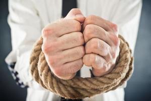 zakenman met handen vastgebonden in touwen