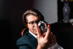 jong Mens Holding een Doorzichtig transparant kristal glas bal in hun hand- foto