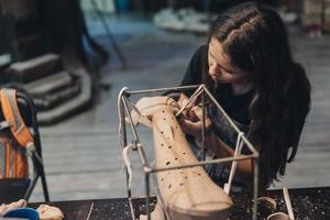 portret van jong vrouw genieten van favoriete baan in werkplaats. foto