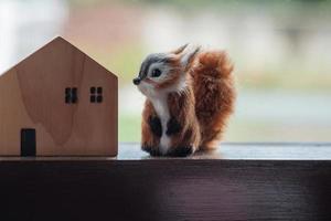 een klein eekhoorn pop en een houten huis dat siert de leven kamer. foto