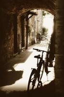 oude geplaveide doorgang met stenen huizen en fietsen foto
