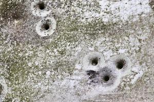 gedetailleerde close-up van kogelgaten van geweerschoten in een verkeersbord foto