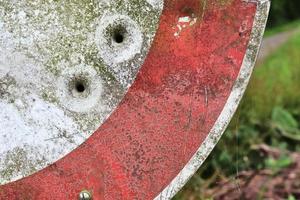 gedetailleerde close-up van kogelgaten van geweerschoten in een verkeersbord foto